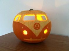 a carved pumpkin with a vw bus on it's face and lights in the eyes