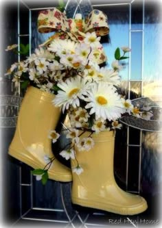 a pair of yellow rain boots with daisies in them