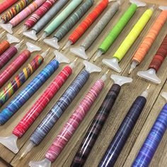 many different colored pens lined up on a table