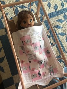 a doll is laying in a baby crib