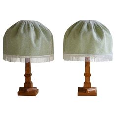 two green lamps with white fringes on them