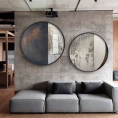 a living room with two circular mirrors on the wall and a couch in front of it