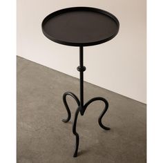 a black table with curved legs and a round tray on the top that is shaped like an animal's tail