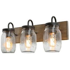 three mason jar lights mounted on a wooden wall light fixture with glass jars and metal fittings