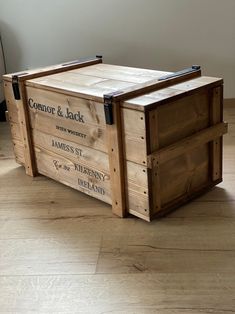 a large wooden crate sitting on top of a hard wood floor next to a wall