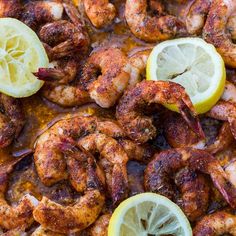 cooked shrimp and lemons on a baking sheet