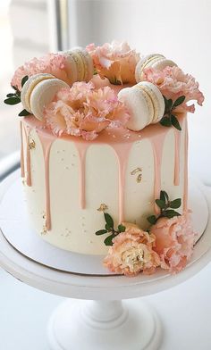 a white cake with pink flowers and shells on top