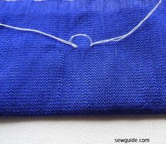 a piece of blue fabric with white thread