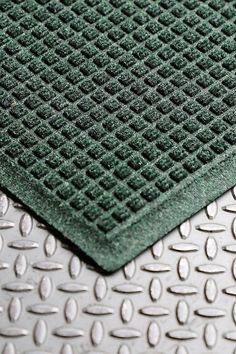 a close up view of a metal surface with green and white dots on the floor