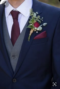 a man in a suit and tie with a boutonniere on his lapel