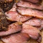 sliced meat sitting on top of a wooden cutting board