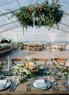 an outdoor dining area with tables and chairs set up for a formal function at the beach