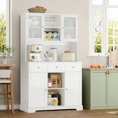 a white cabinet with glass doors and shelves in a kitchen next to a dining room table