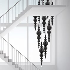 a white staircase with black balls hanging from it