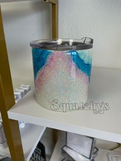 a canister sitting on top of a white shelf next to a bookcase with books