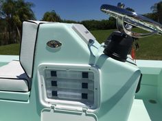 the inside of a motor boat with its seat folded down and storage compartment open on the back