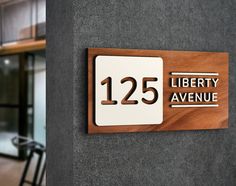 there is a sign that says liberty avenue on the side of a building with chairs in the background