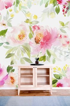 a floral wallpaper with pink flowers and green leaves on the sideboard in front of a white cabinet