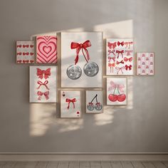 a wall with many different pictures on it and some red bowknots in the middle