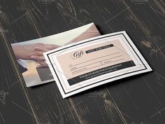 a close up of a person's hand on top of a wooden table with a black and white business card