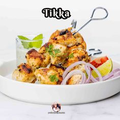 chicken tikka served on a white plate with garnishes