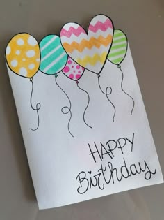 a birthday card with balloons and the words happy birthday written in black ink on white paper