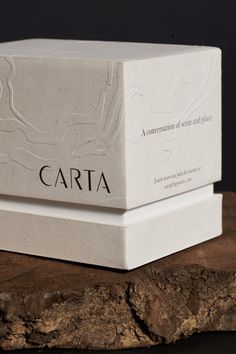 two white boxes sitting on top of a piece of wood with the words carta printed on them