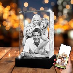 a glass block with an image of a family on it and a phone next to it