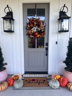 the front door is decorated with pumpkins and gourds to welcome you home