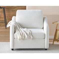 a white chair with a blanket on it