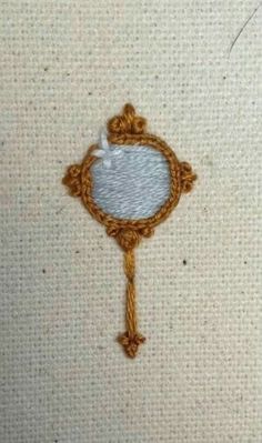 a close up of a piece of cloth with a small mirror on the front and side