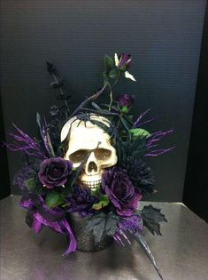 a skull with purple flowers in it on a table