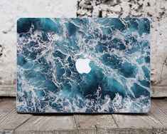 an apple laptop on a table with blue and white marble