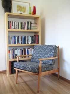 a chair sitting in front of a book shelf filled with books