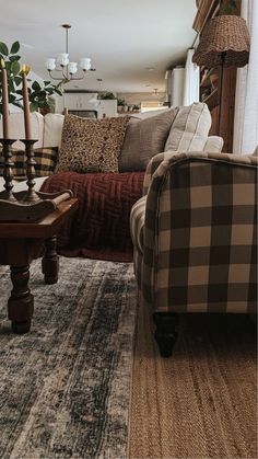 a living room filled with furniture and pillows on top of a carpeted floor next to a window