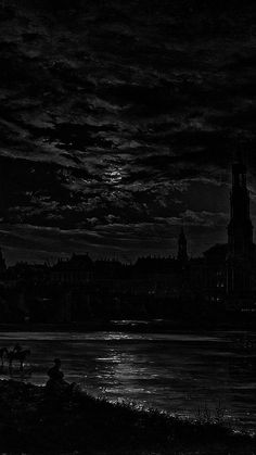 a black and white photo of a city at night with the moon in the sky