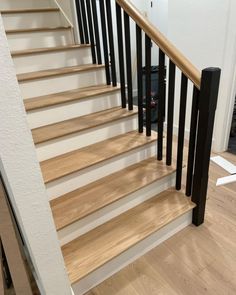 a staircase with black handrails and white walls