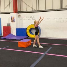 a young woman is practicing her moves on the trampoline in an indoor gym