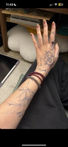 a woman's arm with tattoos on it and a laptop in front of her