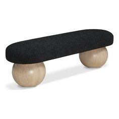 a black skateboard sitting on top of a wooden ball with an oval seat cover