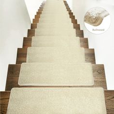 a set of beige carpeted stairs leading up to a white wall with an advertisement on it