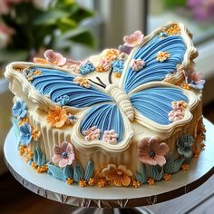 there is a cake decorated with flowers and a butterfly on it's top layer