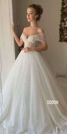 a woman in a white wedding dress posing for the camera