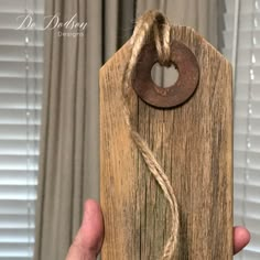 a person holding up a piece of wood that has been made into a door handle