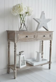 a wooden table with two drawers and flowers on it next to a white star wallpaper