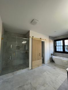 a large bathroom with a glass shower door and tub in the corner next to it