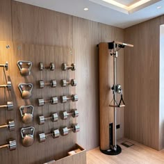 an exercise room with various equipment mounted on the wall and wood paneling behind it