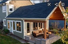 an outdoor living area with couches and chairs in front of a house that is built into the side of a building