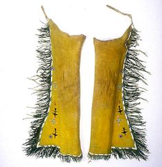 two pieces of yellow cloth with fringes and beads on them are hanging from the wall