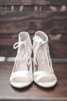 a pair of white shoes sitting on top of a wooden bench